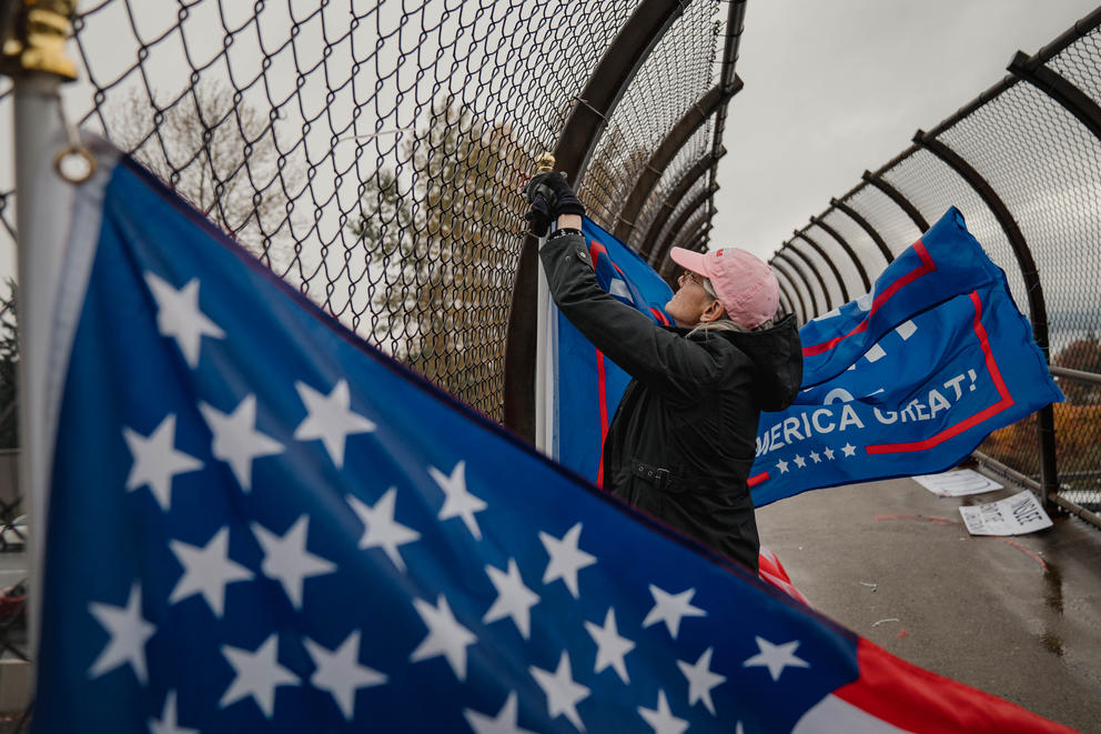 Woman hanging signs and flags in support of Donald Trump