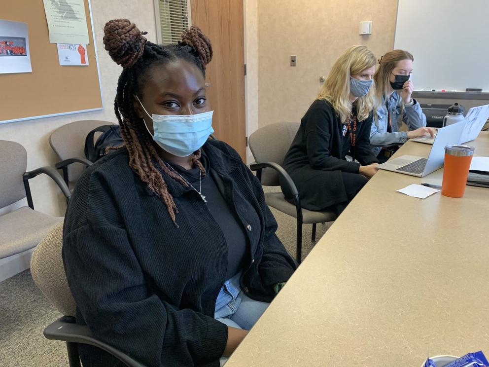 Dayo Onanuga sits in a classroom wearing a face mask