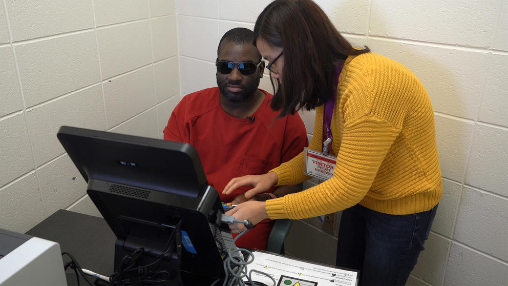 Language Services and Community Engagement Specialist at King County Elections Nhien Huynh assists Jordan Landry, who is visually impaired, as he uses an Accessible Voting Unit to cast a vote 