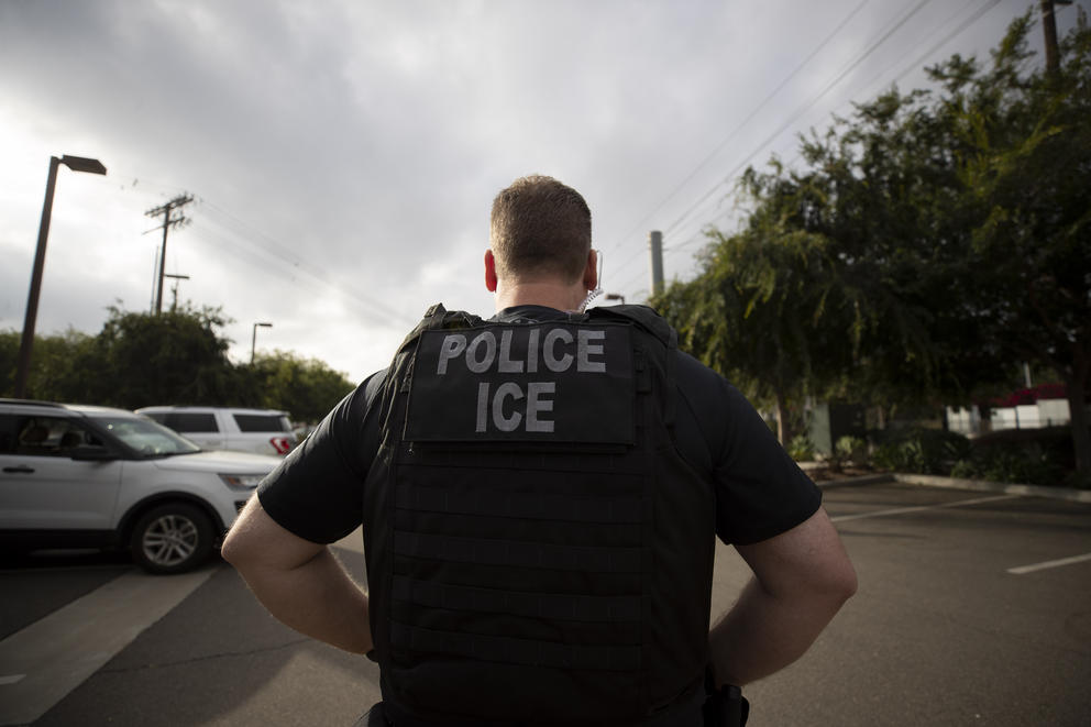 A man wearing a vest reading "Police / ICE"