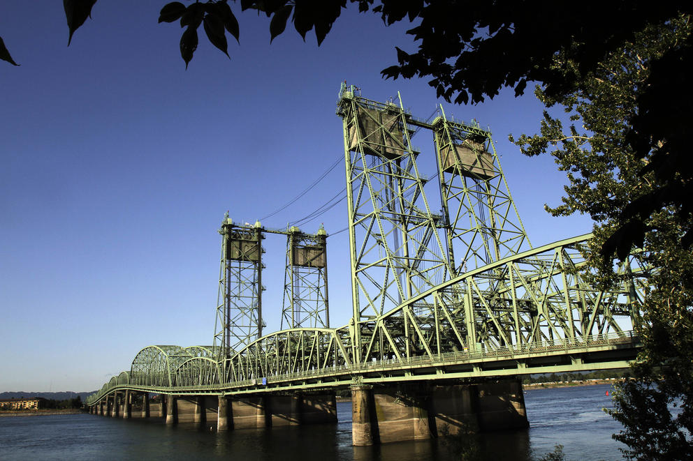 A green bridge against an expansive blue sky