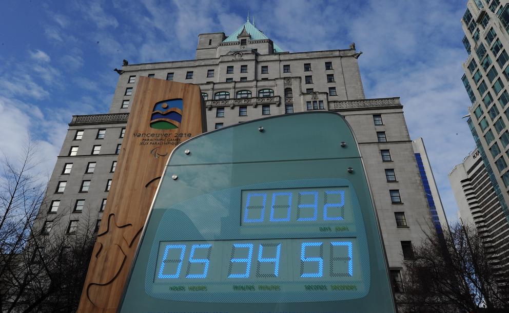 A sign with numbers in front of a tall building.