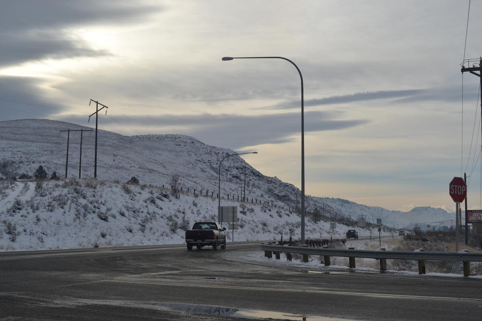 A car travels on a highway on a wintry day