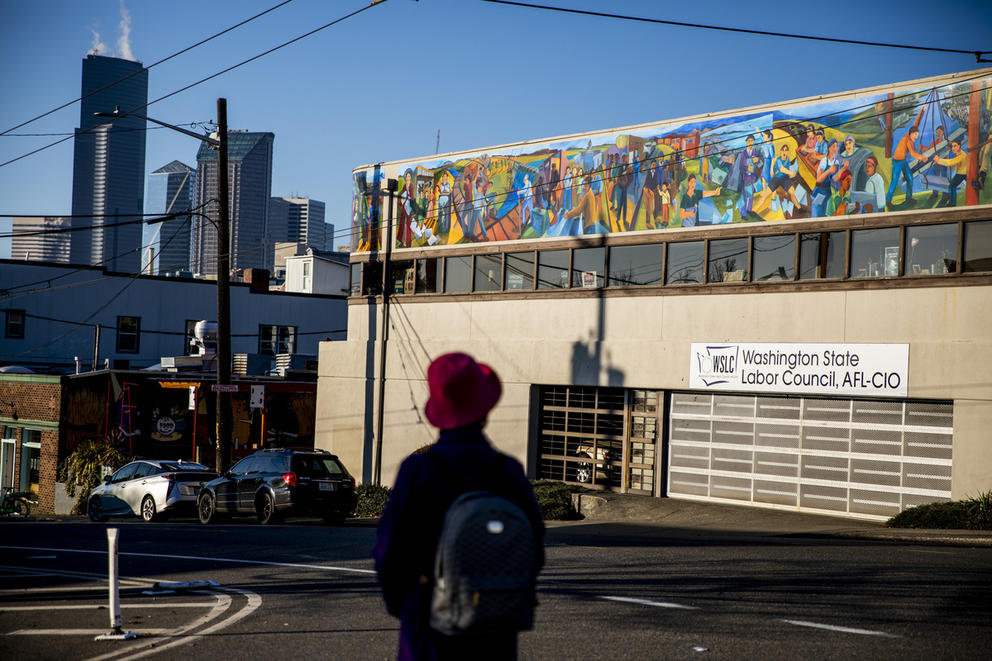 A person near a building with a mural