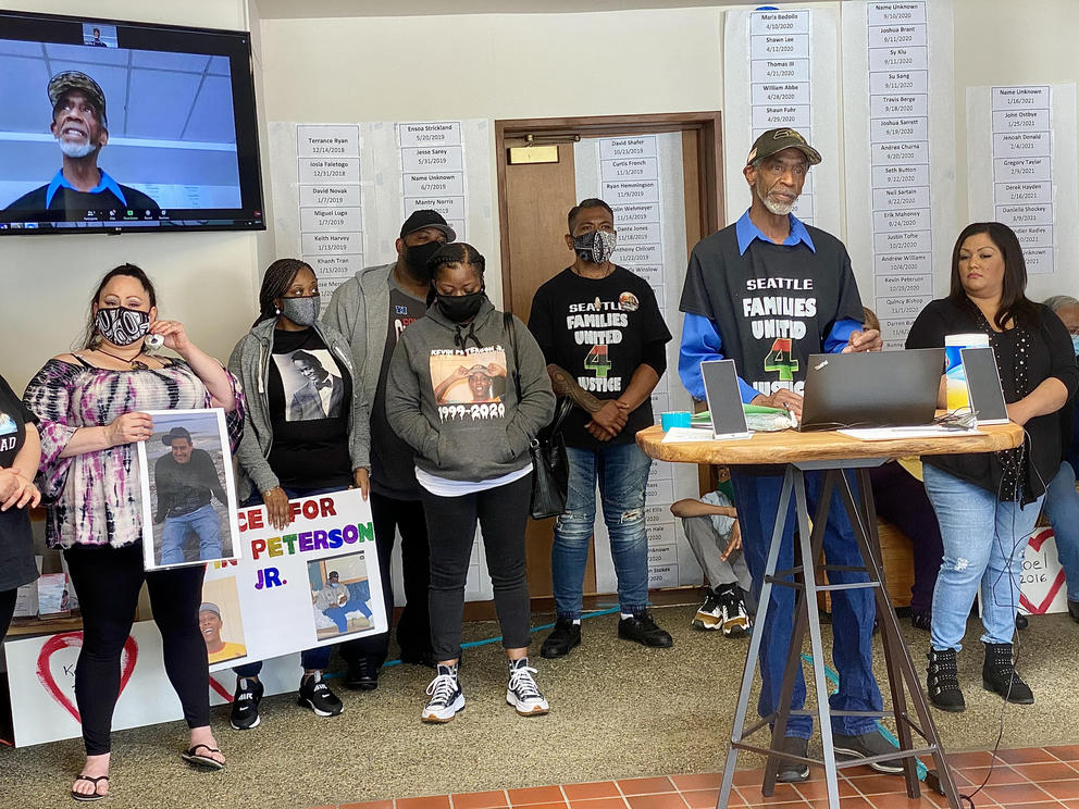 Fred Thomas speaks about legislation he worked to pass, surrounded by family members of other people killed by police