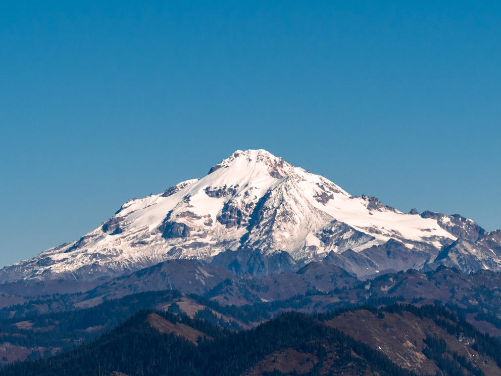 glacier peak covered in glaciers on a blue day