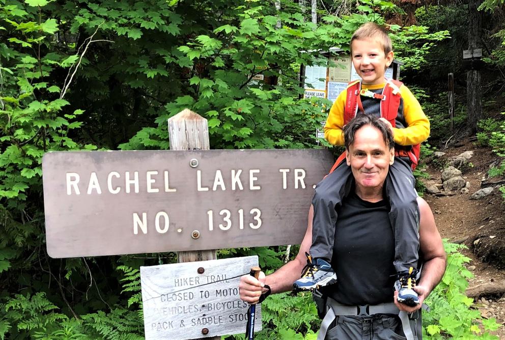 man with child riding piggy-back at trailhead