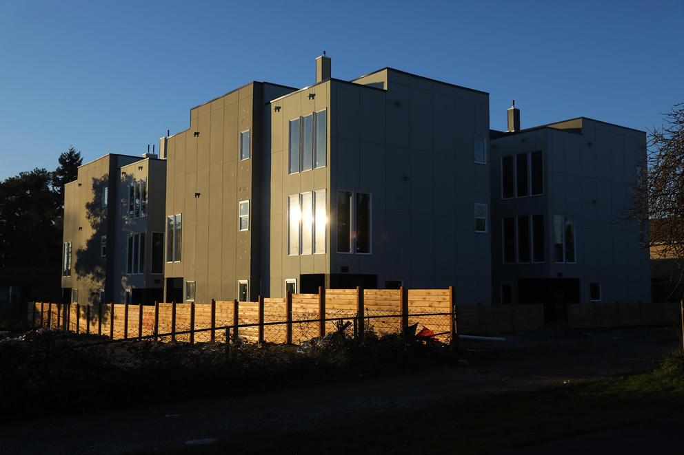 Sun shines off the window of square looking building, surrounded by three similar buildings