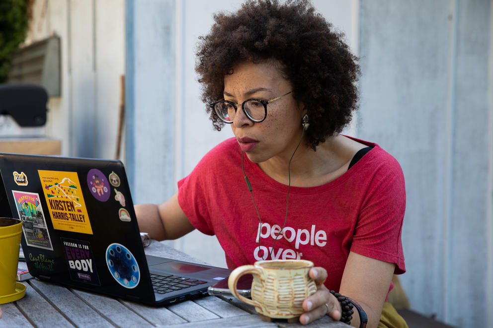 A woman sits in front of a laptop computer