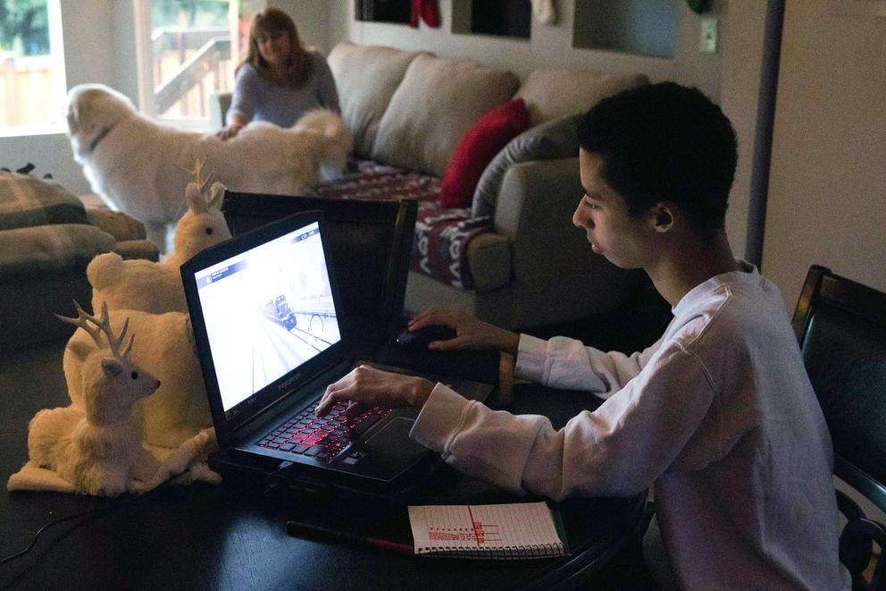 Candace sits while Peyton works on a laptop