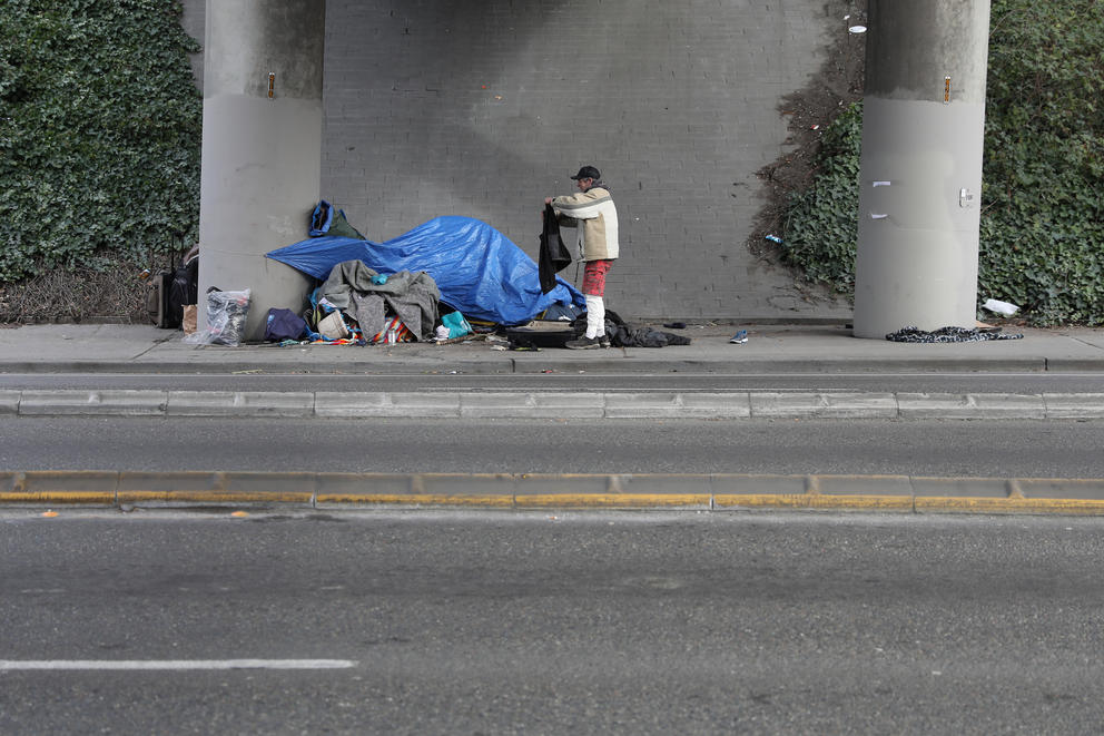 A man stands outside a blue tent