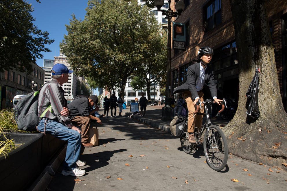 a bicyclist and a homeless man in seattle