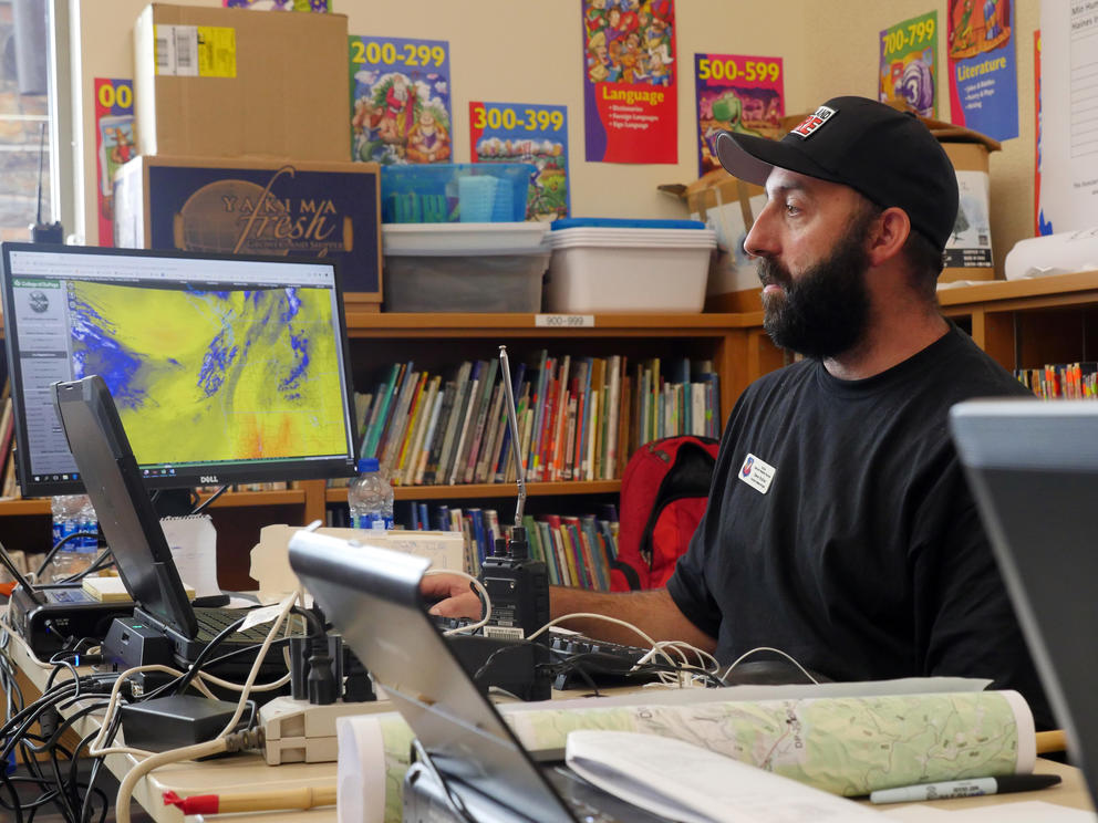 A man looks at a computer screen with mapping software pulled up