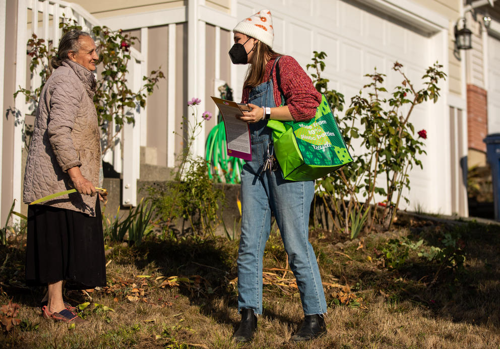 Picture of a canvasser talking to a Tukwila resident about proposal to raise the minimum wage.