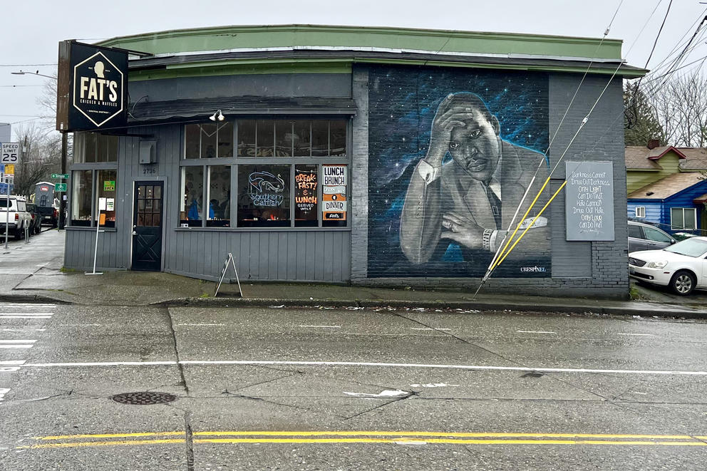 a photo of a building on a Seattle street, left side is Fat's restaurant, right side is a mural of Martin Luther King