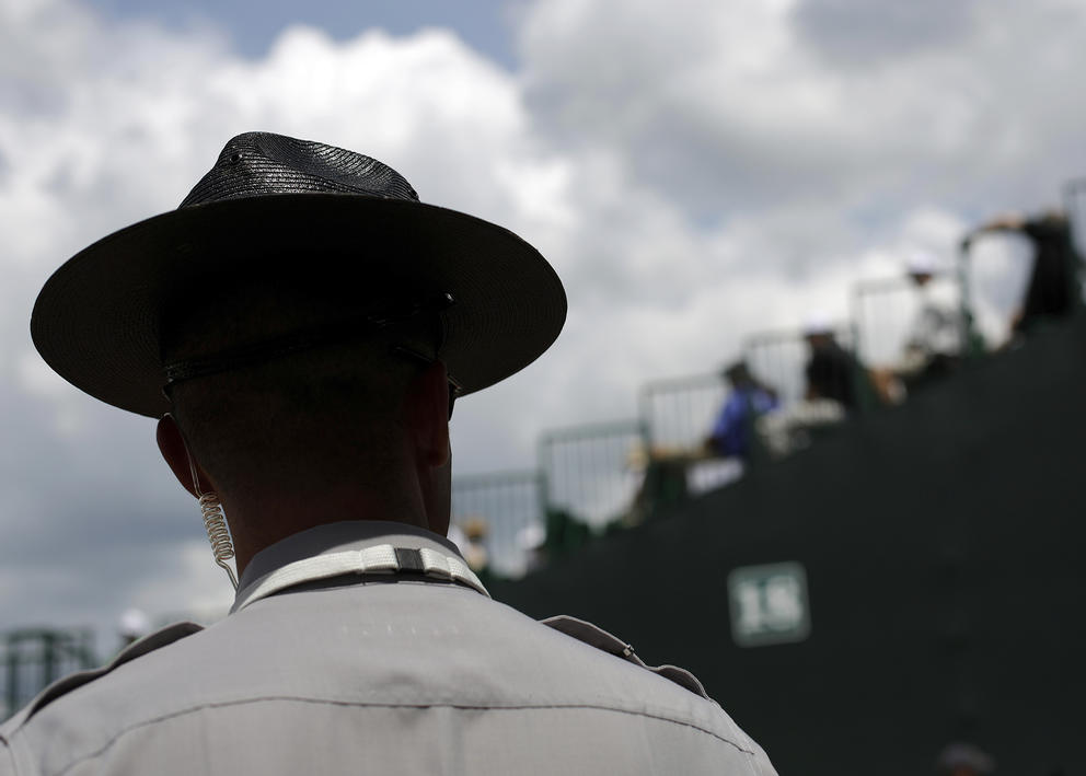 Back of a State Trooper's head and neck as he looks at crowd on bridge