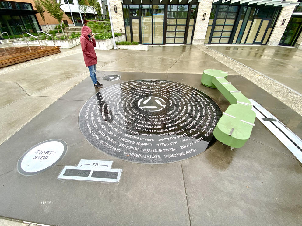 Person in rain coat standing on top of artwork 