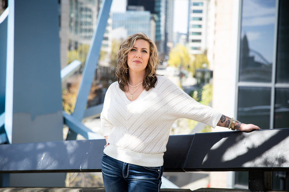 A woman poses outside an office building