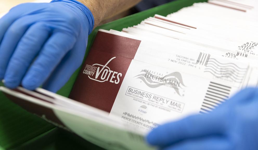 Seasonal Election Worker Greg Thon counts and verifies ballots on Election Day.