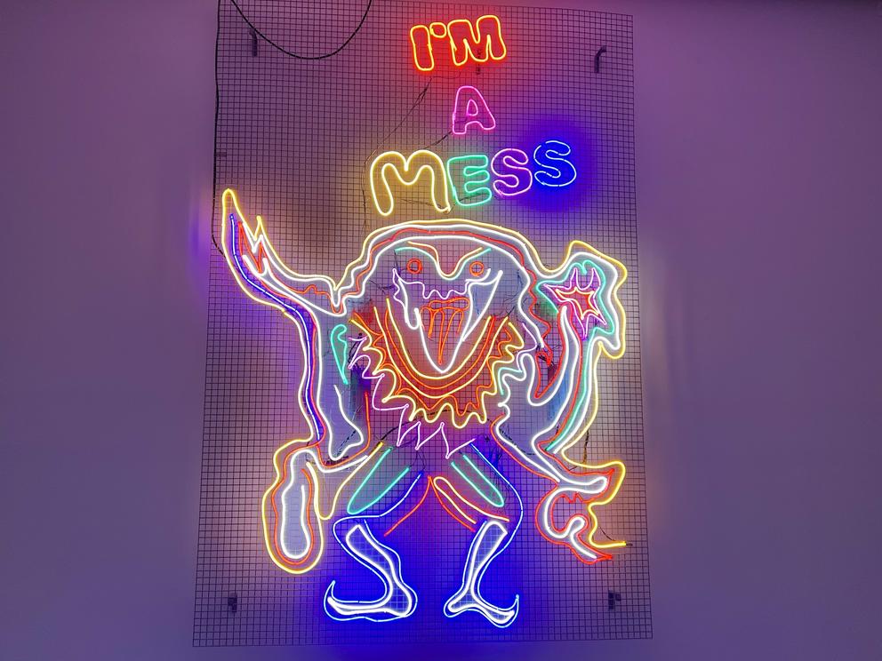 a neon sign that reads "I'm a Mess" with a strange neon creature of many colors