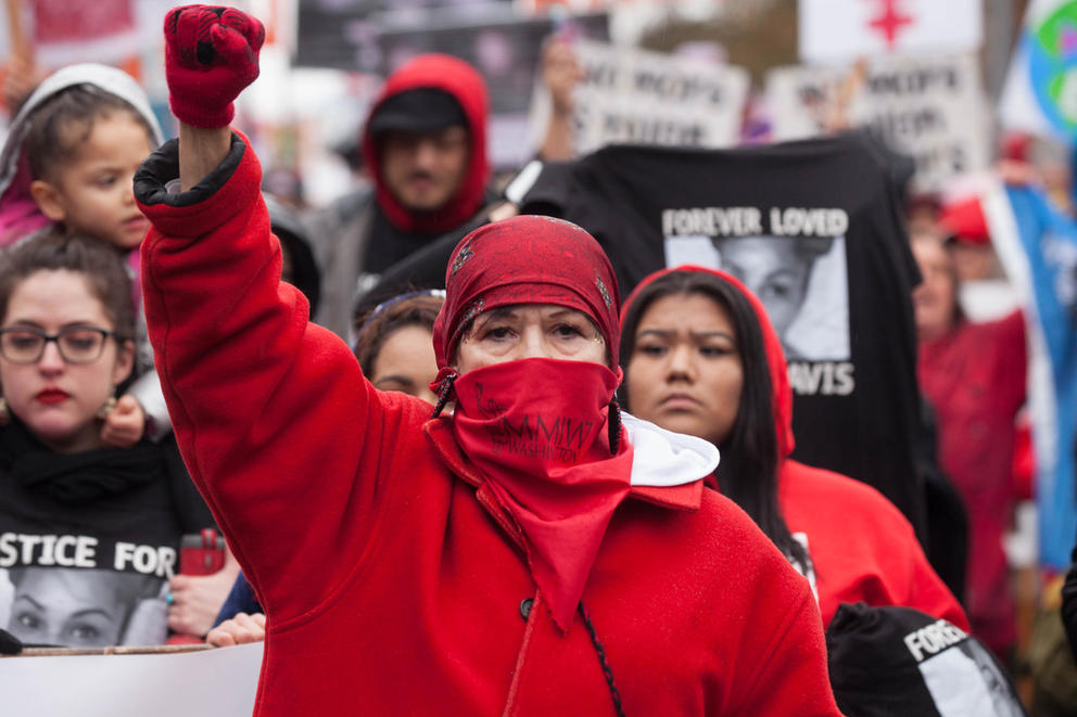 A woman stands with her fist in the air