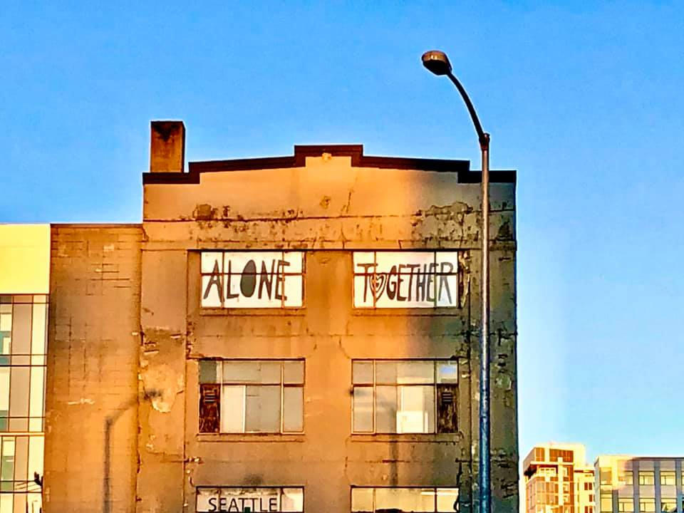 Large brick building with Alone Together coronavirus window art