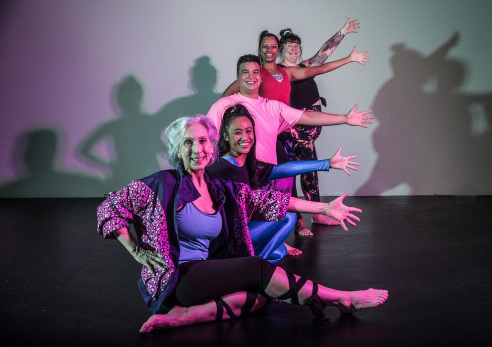 cast members in dance costumes strike a group pose