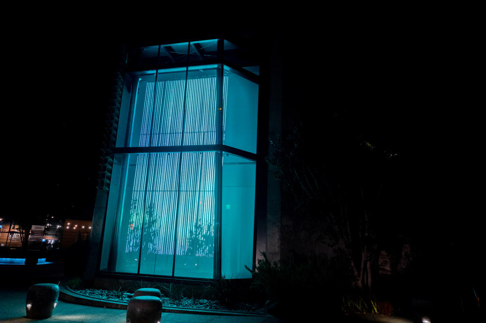 street photo of a two-story window with blue bars of vertical lights 