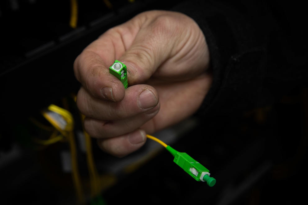 IT coordinator Michael Moore holds bright green wiring between his finger and thumb.
