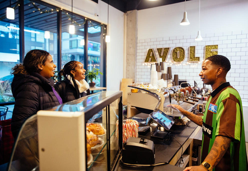 Two customers ordering at a counter in a coffee shop