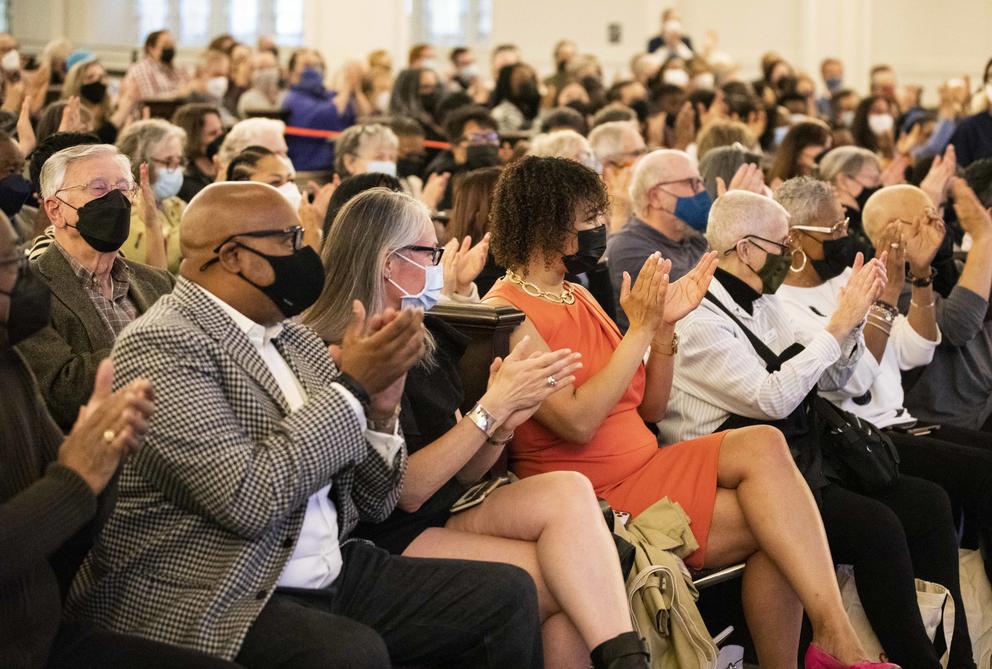 A seated crowd, fully masked