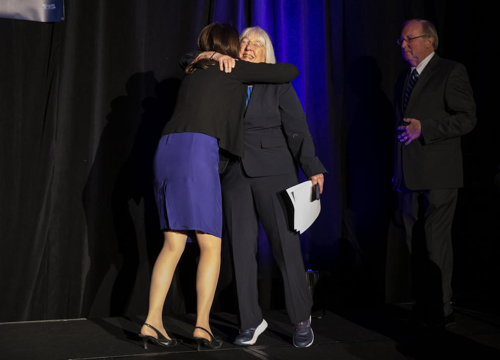 Two women embrace on stage