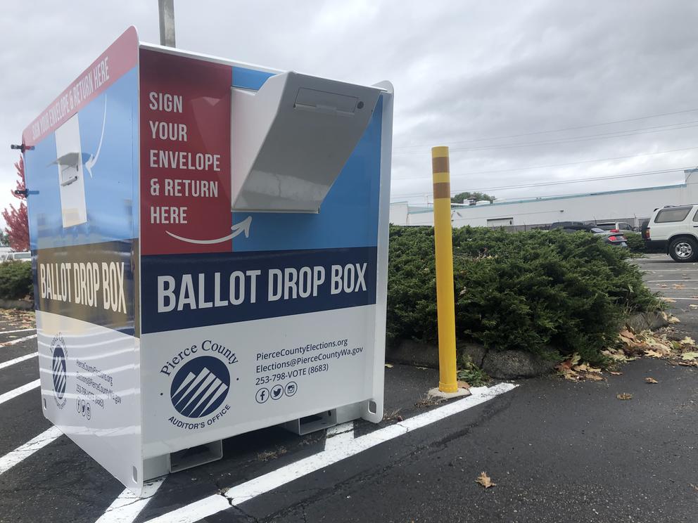 A large ballot drop box in a parking lot