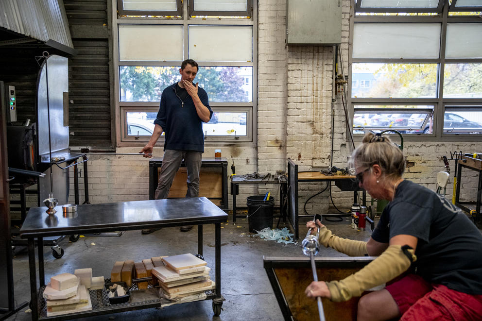 Artists work on blown glass