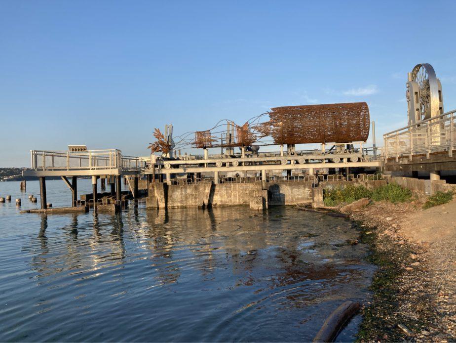 photo of a log sculpture on a river front