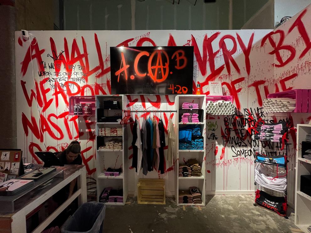 A white wall features bright red text, a closet full of clothing. 