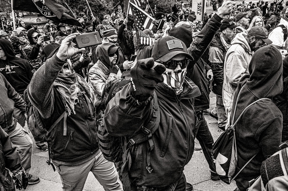 People march, one person points to the camera, photo in black and white 