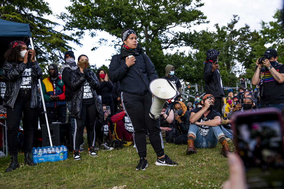 A person in a park holds a megaphone