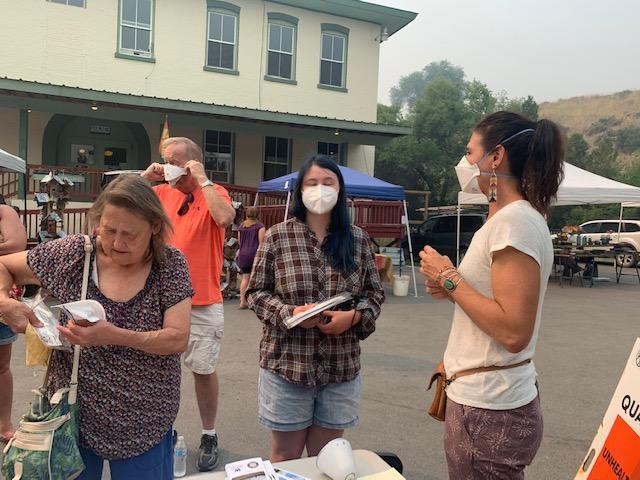 Women gather in parking lot under smoky skies.