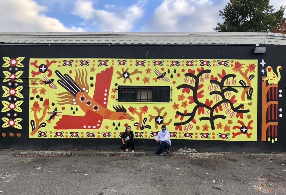 Wall painted yellow featuring a red and orange firebird, tree and a monkey to the right.