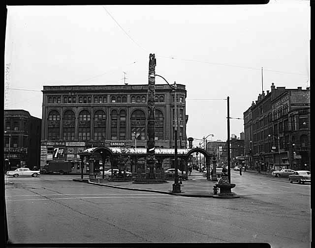 Street scene with building, totem pole and pergola