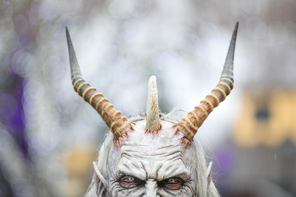 A close up of a man wearing a Krampus mask 