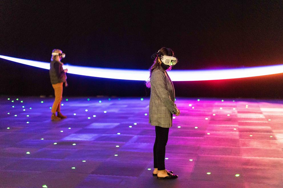 two people in colorful but dark room with vr headsets on