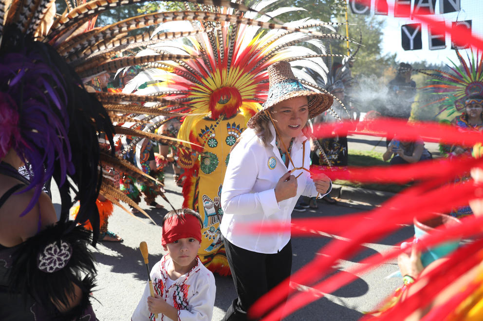 Quinault Indian Nation president fawn sharp marches with feather-adorned fellow tribe members.