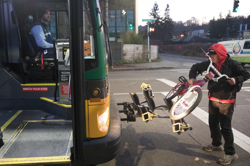 Clay Mclure waits for a passenger to load a bike 