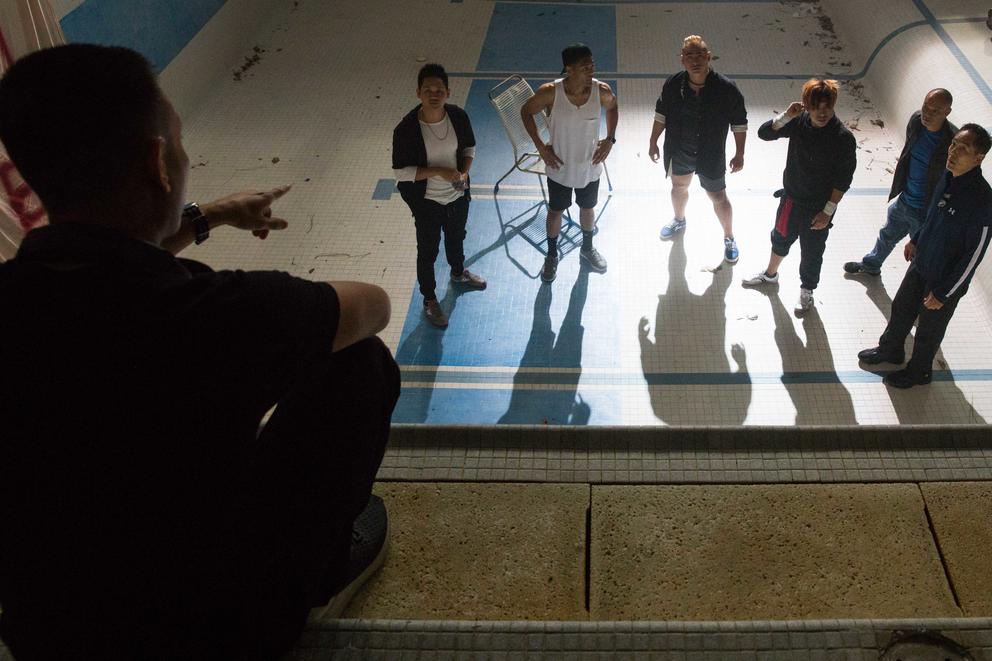 Cast members stand in empty pool