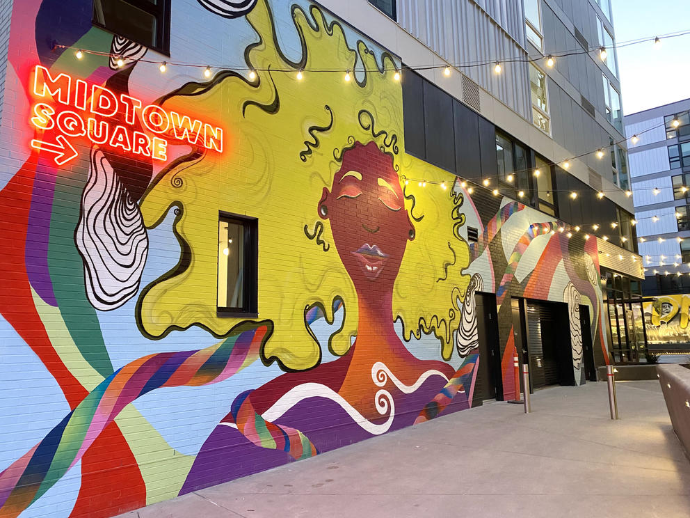 a brightly painted mural of a woman with flowing yellow hair