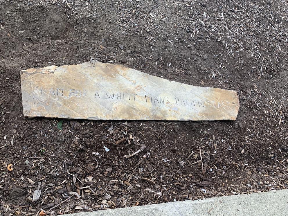 Slab of carved stone on brown soil 