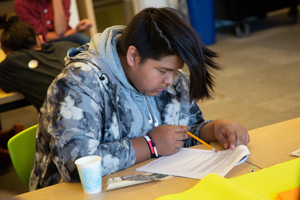 Eric Nichols, 15, reads through a handout 