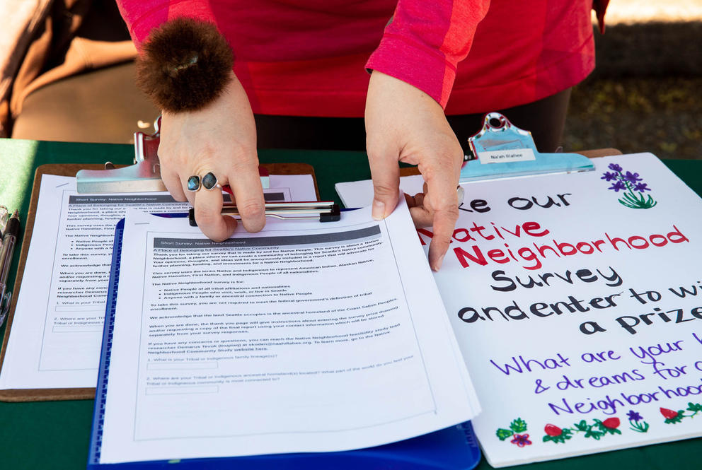 Surveys and information flyers line the table at the Indigenous Vendors Market